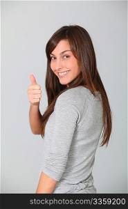 Smiling young woman with thumbs up