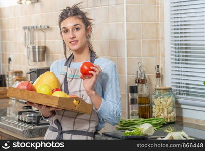 smiling young woman with various fruits in the kitchen