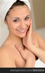Smiling young woman wrapped in towel