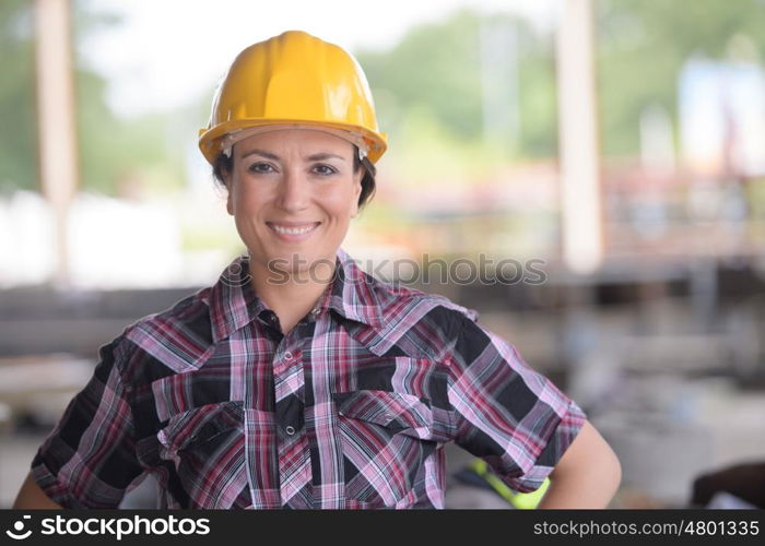 smily female worker wearing a yellow helmet