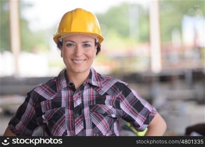 smily female worker wearing a yellow helmet