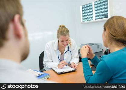 smily young female doctor giving results to patients