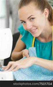 smily young woman sewing with sewing machine