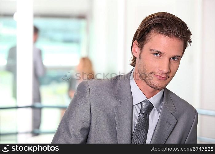 Smirking young executive in a office building