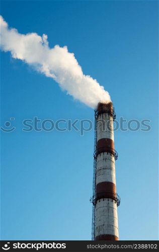 Smoke from a chimney on blue sky background