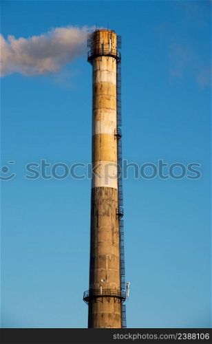 Smoke from a chimney on blue sky background