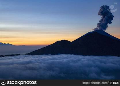 Smoke from explosion rises from volcano Agung on Bali at dusk