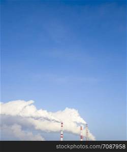 smoke from the chimney of the plant on the background of a clear blue sky, landscape per day. smoke from the chimney