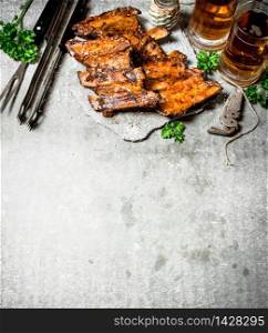 Smoked barbecue ribs with beer and herbs. On a stone background.. Smoked barbecue ribs with beer and herbs.