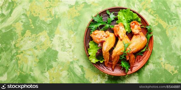 Smoked chicken wings. Smoked chicken wings and leaf salad. Fast food.American Cuisine