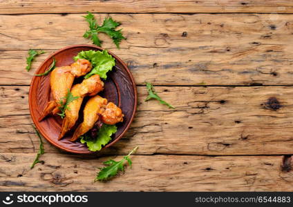 Smoked chicken wings. Smoked chicken wings and leaf salad. Fast food.American Cuisine