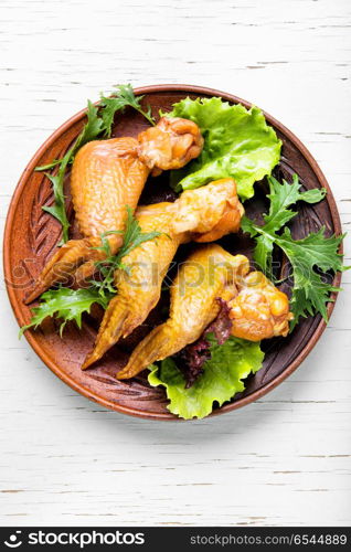 Smoked chicken wings. Smoked chicken wings and leaf salad. Fast food.American Cuisine