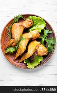 Smoked chicken wings. Smoked chicken wings and leaf salad. Fast food.American Cuisine
