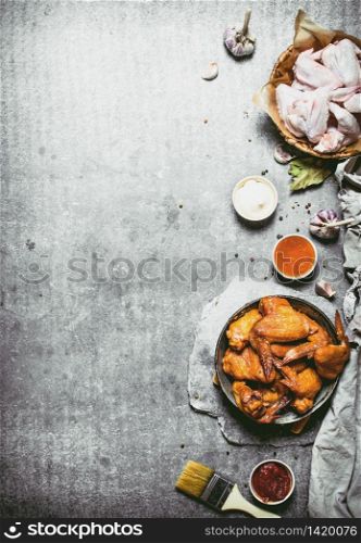 Smoked chicken wings with sauce. On a stone background.. Smoked chicken wings