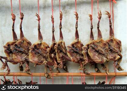 Smoked chikens near the wall in chinese village