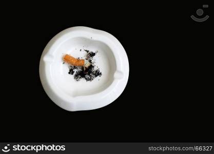 smoked cigarette in white ashtray isolated on black background