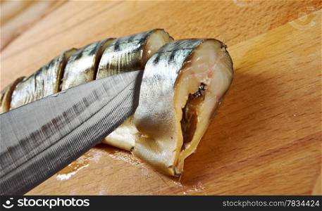 Smoked mackerel cut with slices on a wooden cutting board