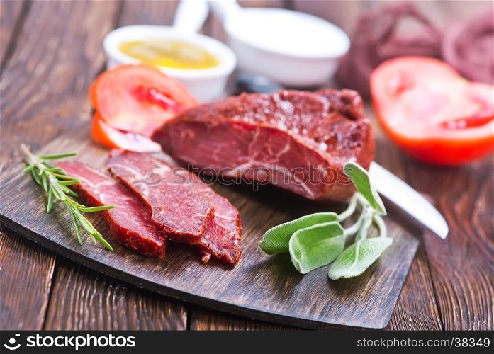 smoked meat with spice on wooden board
