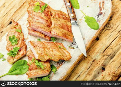 Smoked pork ribs on a wooden kitchen board.. Smoked pork ribs.