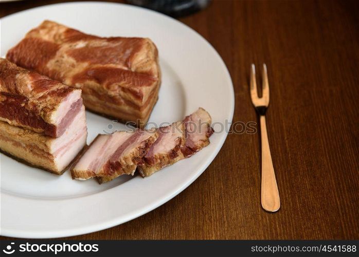 smoked pork ribs on white plate on wooden background