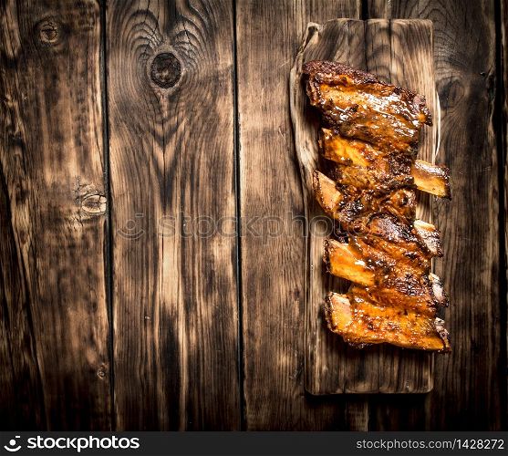 Smoked ribs grilled on the old Board. On a wooden table.. Smoked ribs grilled on the old Board.