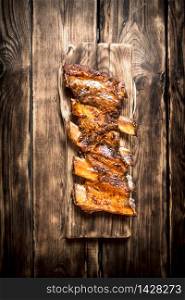 Smoked ribs grilled on the old Board. On a wooden table.. Smoked ribs grilled on the old Board.