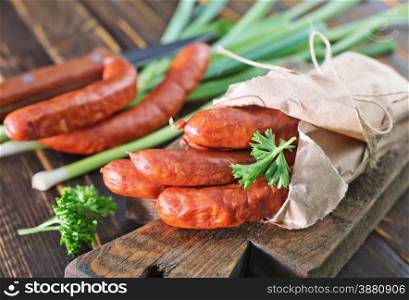 smoked sausages on board and on a table