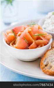 Smoked wild salmon and baguette on plate, close up, selective focus