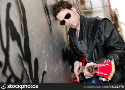 smoking cigarette rock leather boy playing guitar outdoor on silver wall backgorund