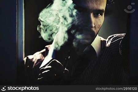 Smoking handsome guy with serious look