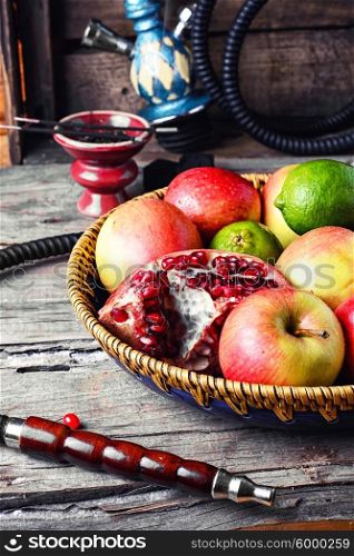 Smoking hookah and basket with apples,pomegranate and lime
