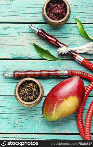 Smoking hookah.Details of shisha.Shisha with mango aroma of tobacco.. Smoking hookah with mango