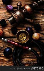 smoking hookah on plums. Turkish smoking pipe with the aroma of autumn plum