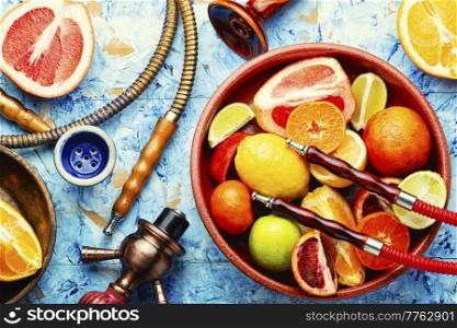 Smoking hookah or shisha with tobacco from fresh citrus fruits. Accessories for making hookah. Eastern with citrus tobacco, smoking