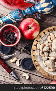 Smoking hookah tobacco with Apple flavor and cashews. Preparation of hookah smoking