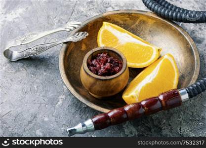 Smoking hookah with the aroma of orange.Details of Oriental hookah.Egyptian kalian. East fruit smoking hookah.