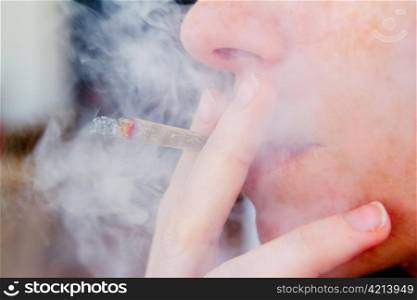 smoking joint closeup with smoke like unhealthy tobacco