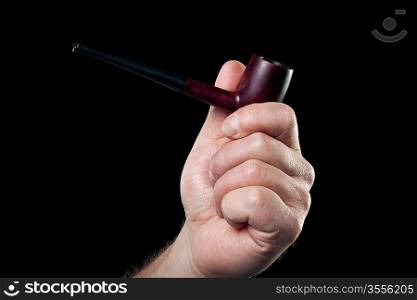 smoking pipe in hand isolated on black background