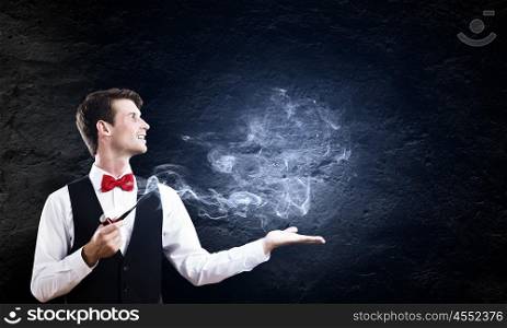 Smoking pipe. Young handsome businessman in fumes smoking pipe