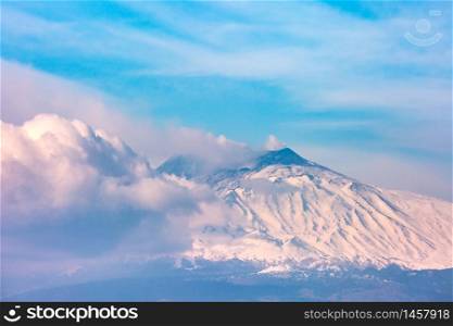 Smoking snow-capped Mount Etna volcano at sunrise, as seen from Taormina, Sicily. Mount Etna at sunrise, Sicily, Italy