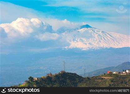 Smoking snow-capped Mount Etna volcano at sunrise, as seen from Taormina, Sicily. Mount Etna at sunrise, Sicily, Italy