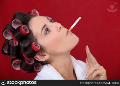 Smoking woman with her hair in rollers
