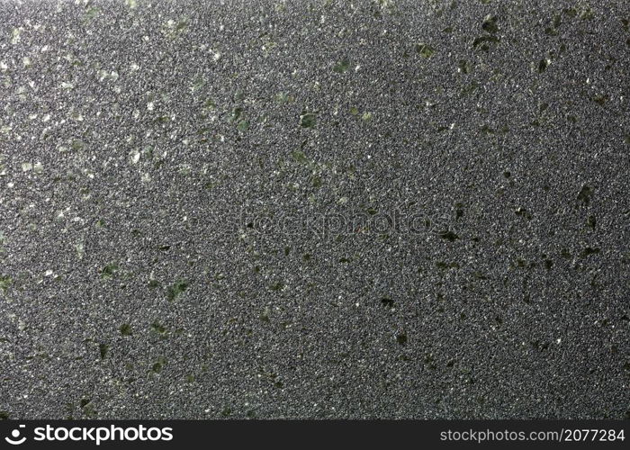 Smooth diagonal gradient with glitter of small colored granules on a black background with green malachite splashes for party decor.. Black shiny background with fine grain texture and green malachite splashes for party decor.