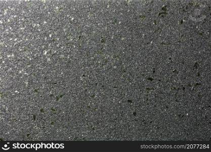 Smooth diagonal gradient with glitter of small colored granules on a black background with green malachite splashes for party decor.. Black shiny background with fine grain texture and green malachite splashes for party decor.