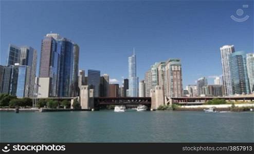 Smooth dolly shot of the Chicago skyline from the water, with boats entering and exiting the Chicago River