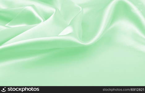 Smooth elegant green silk or satin luxury cloth texture can use as abstract background. Luxurious background design