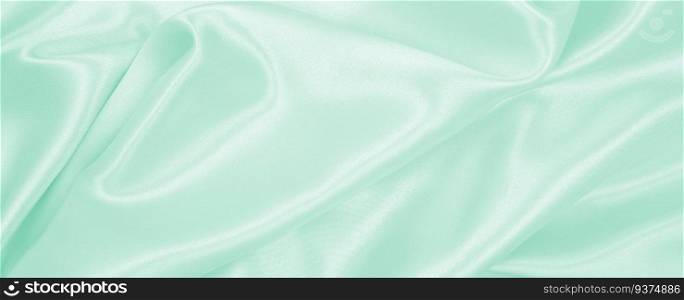 Smooth elegant green silk or satin luxury cloth texture can use as abstract background. Luxurious background design