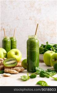 Smoothie. Healthy fresh raw detox spinach smoothie with green apple, kiwi and ginger in a bottles on a table. Healthy diet vegan food full of antioxidants