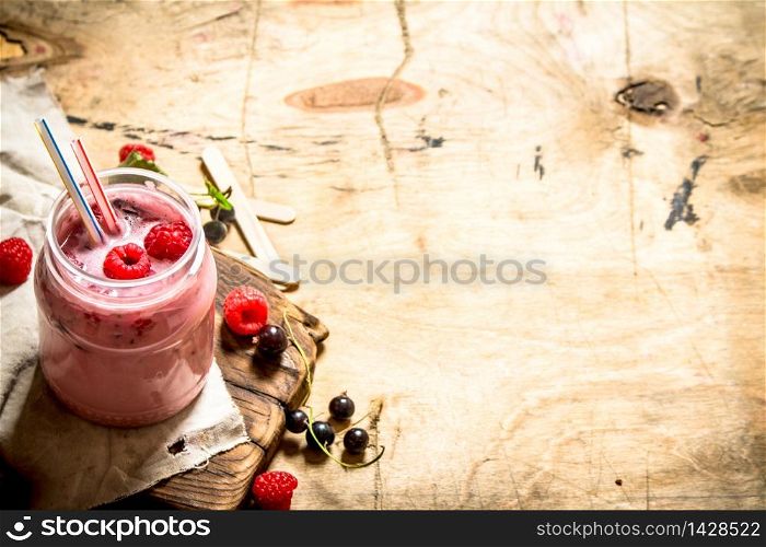 Smoothie raspberry and blackcurrant. On wooden background.. Smoothie raspberry and blackcurrant.
