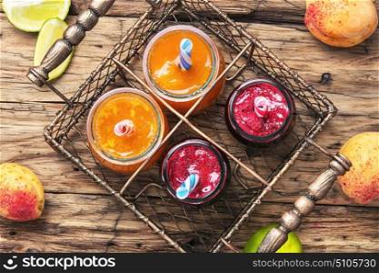 Smoothies with apricot and currant. Jars with apricot and berry smoothies in a stylish metal basket